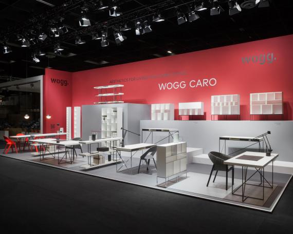 Furniture Fair Cologne 2016 general view Wogg Caro collection by Christophe Marchand displayed on cubic platforms in different shades of grey in front of a  red wall