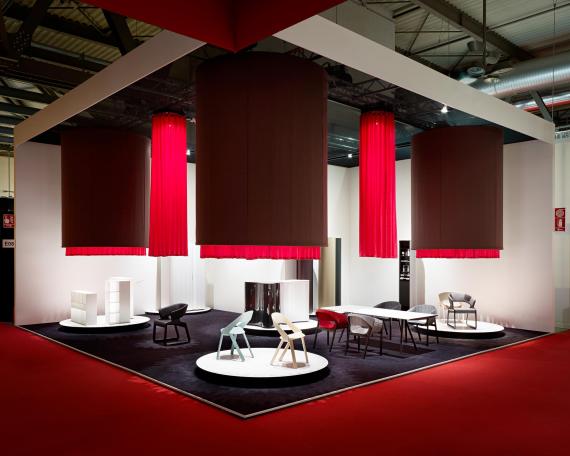 Furniture Fair Milan 2010 exhibition design for Wogg with four hanging fabric cylinders and round display platforms underneath, exhibited furniture from the Amor, Rica and Roya collection