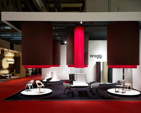 Furniture Fair Milan 2010 exhibition design for Wogg with four hanging fabric cylinders and round display platforms underneath, exhibited furniture from the Amor, Rica and Roya collection