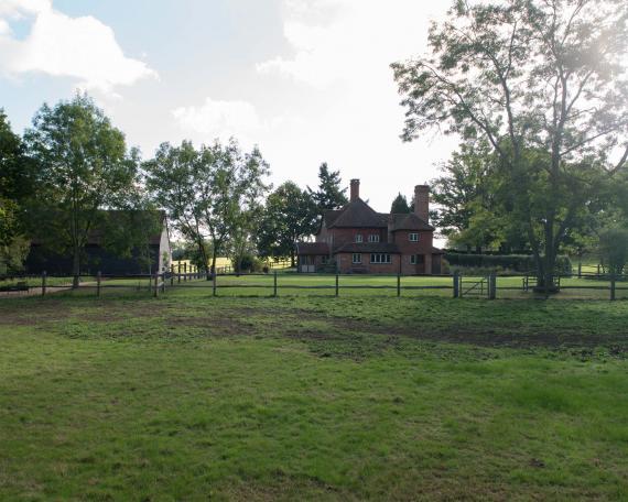 Conversion of barn at Chapel House Farm, Oakwood Hill, Surrey Barn with pre-weathered clapboard and main house with clay shingles and striking chimneys