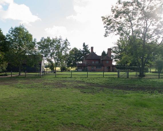 Conversion of barn at Chapel House Farm, Oakwood Hill, Surrey Barn with pre-weathered clapboard and main house with clay shingles and striking chimneys 