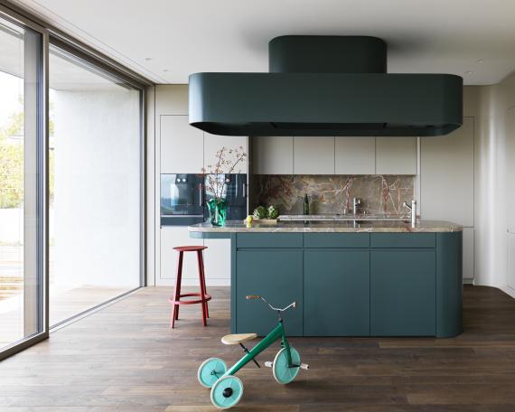 Detail of kitchen island with Arzo natural stone worktop by Schmitt Natursteinwerk and ceiling-mounted hood by Wesco