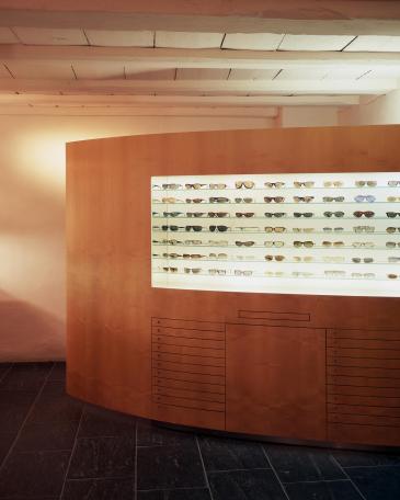 Dudli Optik optician store detail eyewear display wall and consulting tables
