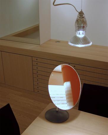 Optik Viegener Detail Spiegel auf Beratungstisch und dahinter Brillenlager