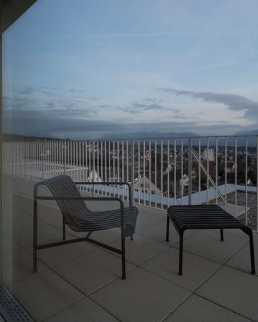 Umbau Mehrfamilienhäuser im Baumgarten in Tann Erweiterung Attika mit Blick vom Wohnzimmer auf die Terrasse und in die Berge