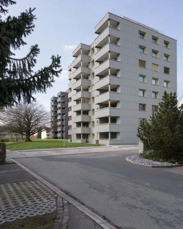 Conversion of apartment buildings on Baumgarten in Tann Balcony extension and new façade with corrugated Eternit Ondapress-36 sheets with open joints and horizontal bands 