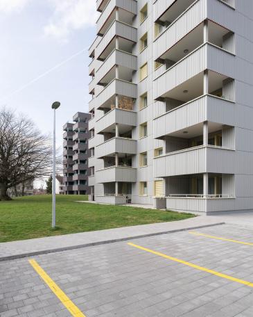 Conversion of apartment buildings on Baumgarten in Tann Balcony extension and new façade with corrugated Eternit Ondapress-36 sheets with open joints and horizontal bands 