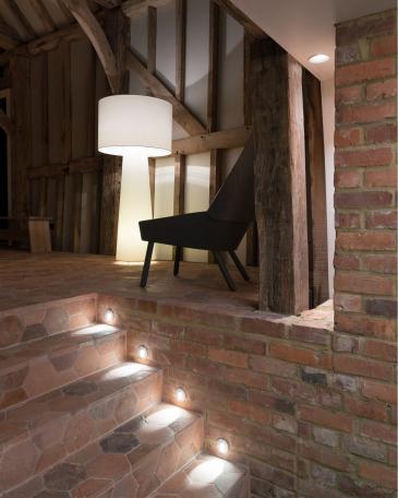 Conversion of barn at Chapel House Farm, Oakwood Hill, Surrey Interior with half-timbered frame and floor with hexagonal terracotta tiles and detail of illuminated stairway