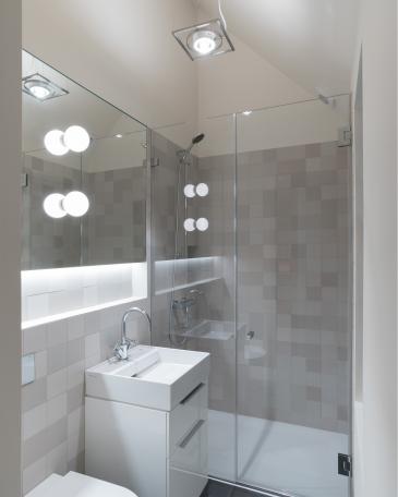 Conversion of barn at Chapel House Farm, Oakwood Hill Bathroom with Mutina Mews Fog stoneware and mirror with Glo-Ball lights from Flos