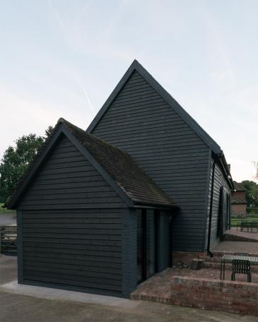 Conversion of barn at Chapel House Farm, Oakwood Hill, Surrey Annex with bathroom and kitchen, facing a brick-paved forecourt