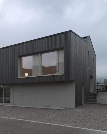 haus wangen nordwestfassade vertikale holzlattenfassade mit vorvergrauung und staketengelaender aus metall als franzoesische balkone