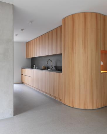 Apartment Lucerne_2_Elm panelling with view into the custom-built kitchen