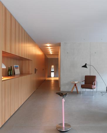 Apartment Lucerne_4_Elm panelling and exposed concrete wall in living room