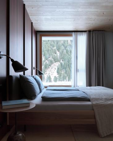 Haus Elva Andermatt Schlafzimmer mit Wandverkleidung in geräucherter Lärche