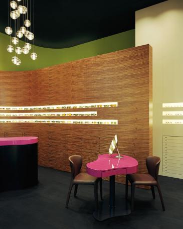Müller Optik optician store showroom with consulting tables in pink and chandelier from Bocci