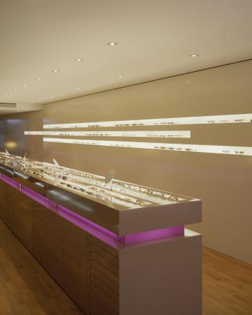 Urech Optik optician store eyewear display cabinets in the middle of the room and display wall at the back